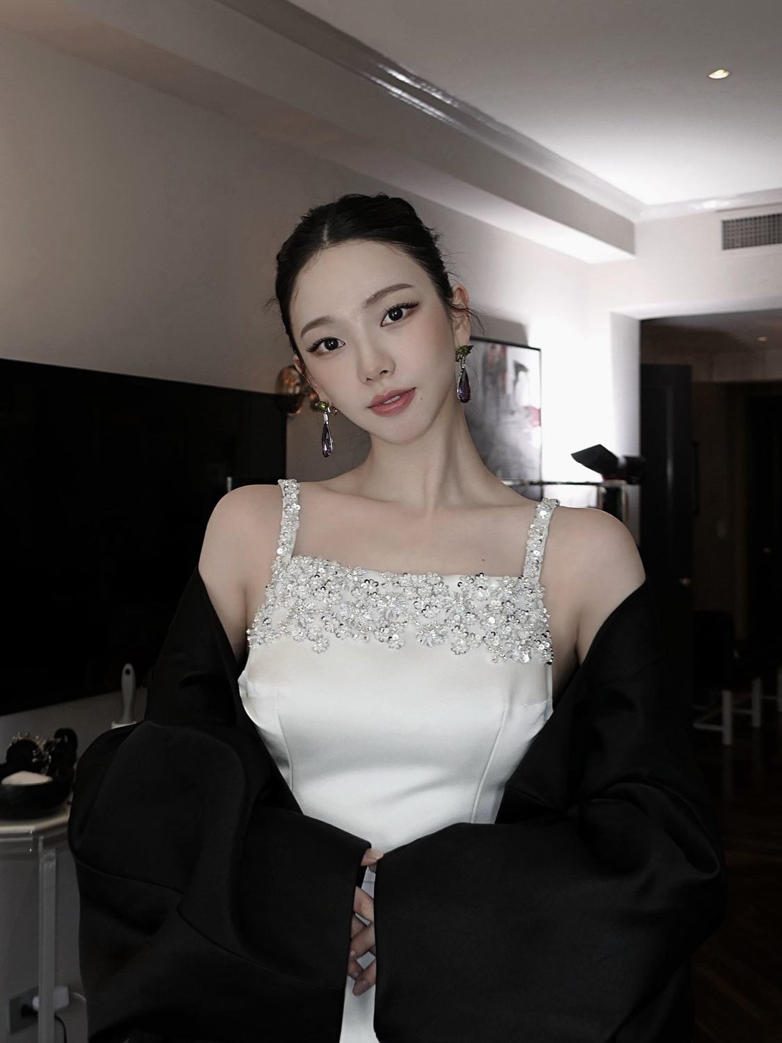 Karina in a white Prada look and black cape backstage