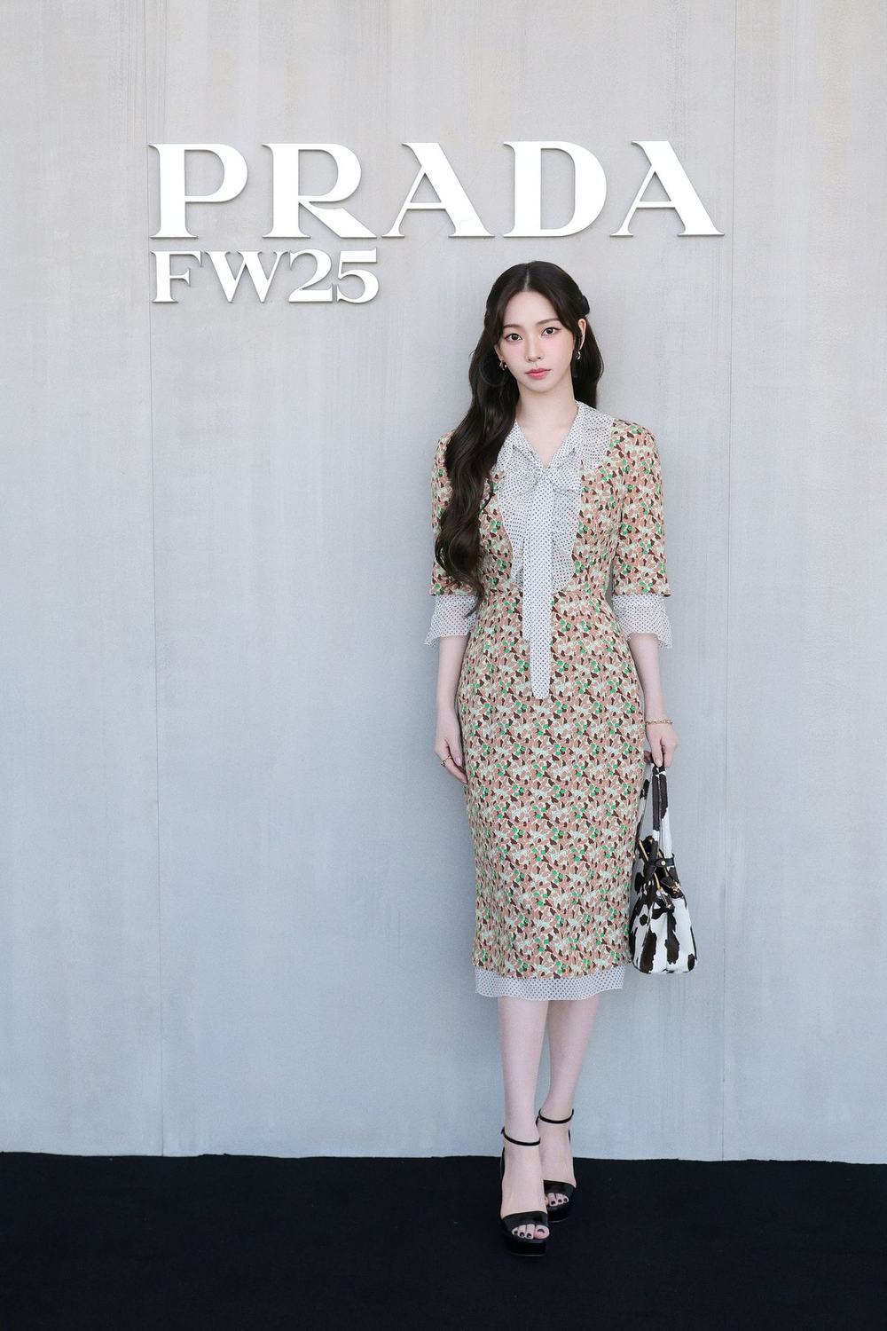Karina at Prada FW25 in front of the Prada logo wall